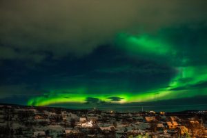 Nothern light over small villag at night. Aurora Borealis